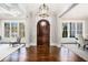 Elegant foyer showcasing a dark wood door, pristine hardwood floors, and abundant natural light at 1005 W Kingston Dr, Atlanta, GA 30342