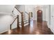 Staircase and dark wooden entry door that accents the bright hallway's hardwood floors at 1005 W Kingston Dr, Atlanta, GA 30342