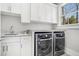 Well-appointed laundry room with modern appliances, custom cabinets, and granite countertop at 1005 W Kingston Dr, Atlanta, GA 30342