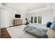 Bright main bedroom featuring a tray ceiling, large windows, and hardwood flooring at 1005 W Kingston Dr, Atlanta, GA 30342