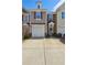 Charming townhome featuring a one-car garage, brick accents, and manicured landscaping at 1914 Lakeshore Overlook Nw Cir, Kennesaw, GA 30152