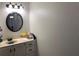 Bathroom vanity with white cabinets, round mirror, and modern lighting at 330 Warm Springs Cir, Roswell, GA 30075