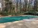 A serene in-ground pool covered for the off-season, surrounded by mature trees and lush landscaping at 330 Warm Springs Cir, Roswell, GA 30075