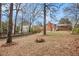 Spacious backyard with mature trees, a fire pit, and a partially fenced yard at 1485 Camelot Ln, Tucker, GA 30084