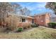 Brick home exterior featuring a manicured lawn and partial fencing at 1485 Camelot Ln, Tucker, GA 30084