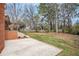 A spacious backyard with a concrete patio and mature trees providing ample shade at 1485 Camelot Ln, Tucker, GA 30084