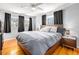 Cozy bedroom with hardwood floors, ample natural light from three large windows, and ceiling fan at 1485 Camelot Ln, Tucker, GA 30084