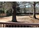 Large, fenced backyard with mature trees and a picnic table in a residential neighborhood at 2031 Lakewood Cir, Grayson, GA 30017