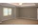 Spacious bedroom with neutral walls and carpet, featuring a tray ceiling with ceiling fan at 2031 Lakewood Cir, Grayson, GA 30017