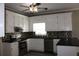 Modern kitchen featuring white cabinets, stainless steel appliances, dark countertops, and stylish backsplash at 2031 Lakewood Cir, Grayson, GA 30017