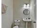 Clean half-bathroom with pedestal sink, round mirror, and decorative light fixture at 2157 Staunton Dr, Duluth, GA 30096