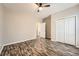 Bedroom with wood-look floors, neutral paint, ceiling fan, and double-door closet at 2985 Pilgrim Mill Rd, Cumming, GA 30041