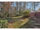 Expansive backyard featuring mature trees, lush greenery, and a brick stairway to upper yard at 545 Spalding Dr, Atlanta, GA 30328