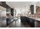 Kitchen with stainless steel appliances, dark cabinets, brick backsplash, open to dining room and living room at 1199 Huff Nw Rd # 109, Atlanta, GA 30318