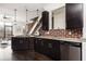 Kitchen with stainless appliances, dark cabinets, brick backsplash, open to living room and staircase at 1199 Huff Nw Rd # 109, Atlanta, GA 30318
