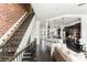 Open-concept living space with brick wall, kitchen island, and staircase at 1199 Huff Nw Rd # 109, Atlanta, GA 30318