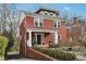 Angle view of a brick two-story home, showcasing a well-maintained lawn, brick retaining wall and covered front porch at 1241 Briarcliff Rd, Atlanta, GA 30306