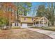 Inviting two-story home with covered porch, stone accents, and mature trees in a peaceful setting at 8640 Embrey Dr, Jonesboro, GA 30236