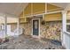 Covered porch with wood floors, stone facade, and black front door at 8640 Embrey Dr, Jonesboro, GA 30236