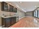 A basement with laminate floors includes a wet bar with dark cabinets and granite countertop, plus a wine fridge at 2837 Captain Ct, Dacula, GA 30019