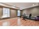 A home gym with laminate floors features two bright windows, exercise equipment, and a sleek, modern design at 2837 Captain Ct, Dacula, GA 30019