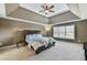 Primary bedroom with tray ceiling, ceiling fan, and lots of light at 2837 Captain Ct, Dacula, GA 30019