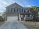 Charming two-story brick home featuring a covered porch, attached two-car garage and beautifully landscaped front yard at 3309 Gardenside Walk, Loganville, GA 30052