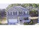 Aerial view of a charming two-story brick home featuring a covered porch and an attached two-car garage at 3309 Gardenside Walk, Loganville, GA 30052