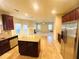 Spacious kitchen with stainless steel appliances, granite countertops, an island, and seamless flow to the living area at 3309 Gardenside Walk, Loganville, GA 30052
