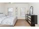 Bedroom with a floral pattern bedspread, wood floors, and a mirrored dresser at 1399 Legrand Cir, Lawrenceville, GA 30043