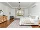 Bright bedroom featuring hardwood floors, a decorative chandelier, and a large window with views of the yard at 1399 Legrand Cir, Lawrenceville, GA 30043