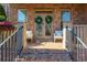 Covered front porch with brick floor, chairs, and decorative wreaths at 1399 Legrand Cir, Lawrenceville, GA 30043