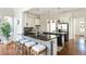 Modern kitchen with black countertops, island seating, stainless steel appliances, and hardwood floors at 1399 Legrand Cir, Lawrenceville, GA 30043