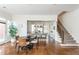 Open floor plan showcasing dining area, view of kitchen with island seating, and stairs with patterned carpet runner at 1399 Legrand Cir, Lawrenceville, GA 30043