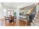 Open floor plan showcasing dining area, view of kitchen with island seating, and stairs with patterned carpet runner at 1399 Legrand Cir, Lawrenceville, GA 30043