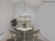 Elegant dining room with a chandelier and seating for four, digitally staged at 1404 Haven Cir, Douglasville, GA 30135