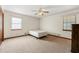 Spacious bedroom with neutral carpet, ceiling fan, and ample natural light at 1465 Rockbridge Rd, Stone Mountain, GA 30087