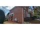 Side view of a brick house showing the covered porch, a well-maintained lawn, and a glimpse of the architectural details at 3302 Fieldwood Se Dr, Smyrna, GA 30080