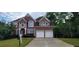 Traditional brick home featuring a two-car garage and manicured lawn, perfect for suburban living at 3302 Fieldwood Se Dr, Smyrna, GA 30080