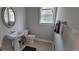 Neat powder room features a pedestal sink, round mirror, and tiled floors at 3302 Fieldwood Se Dr, Smyrna, GA 30080