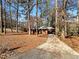 Single-story brick home nestled among mature trees, featuring a covered carport at 4227 Pine Cir, Forest Park, GA 30297