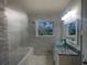 Updated bathroom with a granite countertop, glass bowl sink, tiled tub surround, and tiled floor at 1376 Cornwall Rd, Decatur, GA 30032