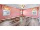 A bedroom view that includes wood floors, light pink walls and two windows at 1717 Ramblewood Way, Snellville, GA 30078