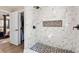 Modern bathroom shower featuring marble tile, a built-in niche, and contrasting mosaic floor tiles at 1915 Pine Rd, Dacula, GA 30019