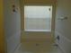 Clean bathroom featuring a white tiled tub and a window offering natural light at 1975 Lily Stem Trl, Auburn, GA 30011