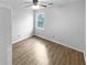 Bedroom with neutral walls, wood floors, ceiling fan and a window at 1302 Milstead Ne Trce, Marietta, GA 30066