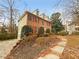 Charming two-story brick home featuring a manicured front lawn with mature trees at 1302 Milstead Ne Trce, Marietta, GA 30066