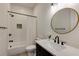 Stylish bathroom with a black and white color scheme, round mirror, and modern fixtures at 1537 Harts Mill Ne Rd, Brookhaven, GA 30319