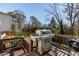 Outdoor deck with a stainless steel grill, overlooking a private backyard with mature trees at 1537 Harts Mill Ne Rd, Brookhaven, GA 30319