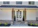 Inviting front porch with wood columns, elegant lighting, and meticulously maintained landscaping at 1537 Harts Mill Ne Rd, Brookhaven, GA 30319